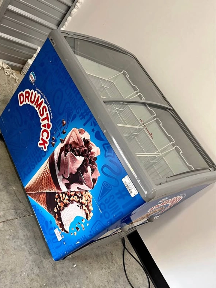 Commercial glass-top ice cream freezer merchandiser with Drumstick / Nestlé branding